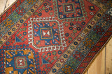 A vintage Karaja rug runner's detailed geometric pattern and even wear over the knot heads.