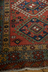 Detailed view of a vintage Karaja rug's geometric hook and latch medallion and floral borders.
