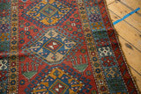 Geometric latch-hook medallions and floral cross sections on a vintage Persian Karaja rug runner.