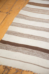 Hand-woven texture with varying natural brown and ivory stripes on a Moroccan Kilim.