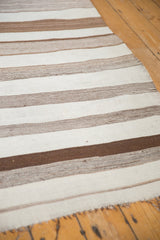 Hand-woven Moroccan Kilim runner with varied natural brown and ivory striped texture, showing fringe.