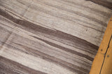 Natural undyed yarn striations and hard abrashes in brown and beige on a Moroccan Kilim.