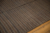 Moroccan Kilim runner with repeating brown and ivory striped bands and dashed lines.