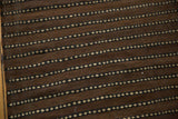 Hand woven Moroccan Kilim rug showing brown and ivory horizontal striped dash pattern.