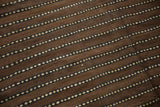 Textured natural wool showing chocolate brown, coffee, and ivory dashed stripes.
