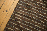 Hand-woven chocolate brown and ivory dashed lines of the Moroccan Kilim.