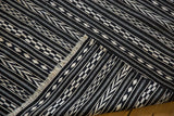 Folded vintage Moroccan Kilim rug with geometric black and ivory checker, arrow patterns and fringe.