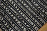 Hand-woven Moroccan Kilim runner showing geometric black, charcoal, ivory checker and arrow motifs.