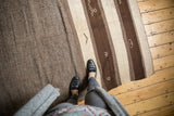 Textured striated brown and ivory bands with geometric patterns on a Moroccan Kilim.