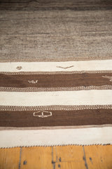Coffee brown and ivory striated bands with geometric motifs on a vintage Moroccan Kilim.