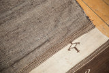 Moroccan Kilim runner with a geometric plant motif on ivory and striated brown bands.
