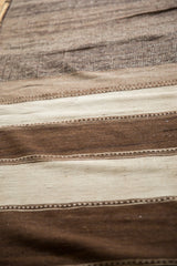 Striated hand-woven texture of a vintage Moroccan Kilim rug in chocolate brown and ivory.