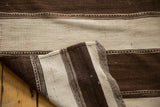 Hand-woven texture of vintage Moroccan Kilim rug, chocolate and ivory geometric striated bands.