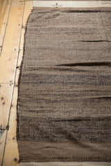 Hand woven texture of a vintage Moroccan Kilim rug with striated chocolate and ivory bands.