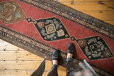 Detail of Karabagh runner's herati motif medallion in navy, madder red, and bronze.