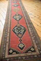 Visible Armenian Karabagh runner detail: navy herati medallion on madder red with geometric border.