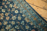 Vintage Lilihan runner close-up with intricate blue floral motifs and a patterned border.