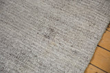Detail of the hand-woven Turkish Kilim carpet, showing its mottled ivory and charcoal texture.