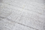 Turkish Kilim carpet's ivory and charcoal black speckled, hand-woven texture.