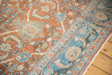 Distressed Mahal carpet's dusty teal border and worn terracotta field with splayed floral motifs.