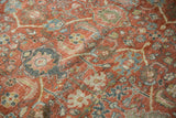 Worn pile texture and terracotta, teal, ivory floral motifs on a vintage Mahal rug.