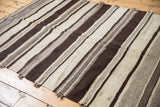 Alternating natural undyed ivory and chocolate brown stripes of the Moroccan Kilim runner.
