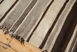 Vintage Moroccan Kilim runner showing textured ivory and chocolate brown striped patterns and fringe.