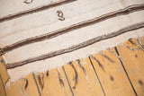 Moroccan Kilim rug end showing ivory plainwoven areas, dark brown stripes, and wispy blooming pile.