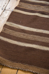 Hand-woven vintage Moroccan Kilim detail with striated chocolate brown and ivory geometric bands.