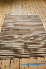 Moroccan Kilim rug with striated beige, coffee, and dark brown flat weave stripes.