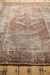 Distressed vintage Karaja rug end, geometric brick red border, visible wear.