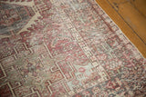 Visible wear showing foundation through distressed geometric patterns in brick red and pale seafoam green.
