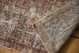 Distressed vintage Karaja rug's worn pile and foundation, with the back and fringe visible.