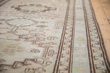 Geometric border of a distressed vintage Serab runner with coffee brown and pale blue.