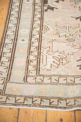 Geometric coffee brown border with pale blue on a distressed vintage Serab rug.