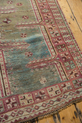 Distressed raspberry red and ivory geometric border with short fringe on vintage Oushak rug.