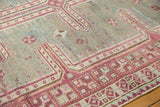 Distressed raspberry red and sky blue maze-like geometric pattern on a vintage Oushak rug.