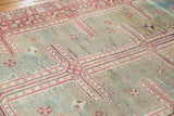 Distressed Oushak rug detail: geometric maze pattern with raspberry, sky blue, and antique ivory, showing even wear.