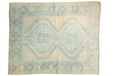 Distressed vintage Afshar carpet featuring muted beige and blue geometric diamond medallions.