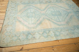 Geometric pale blue medallion, distressed pile, pale rose and ivory field of a vintage Afshar rug.
