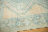 Distressed vintage Afshar rug close-up, worn pale blue patterns on soft beige and rose hues.