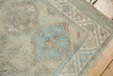 Distressed Afshar rug corner, geometric serrated diamond pattern, muted ivory and sky blue.