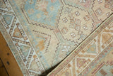 Vintage Distressed Afshar rug's geometric border, serrated pattern, and faded blue, ivory, peach hues.