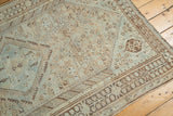 Distressed vintage Shiraz rug with geometric patterns in faded sky blue, peach, and brown tones.