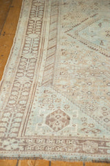 Distressed vintage Shiraz rug: geometric border, faded pile in sky blue and peach tones.