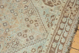 Distressed hand-knotted Shiraz rug: faded sky blue, peach, and brown geometric motifs.