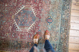 Classic Karaja rug: ivory-outlined blue geometric medallion, brick red field, and textured wear.