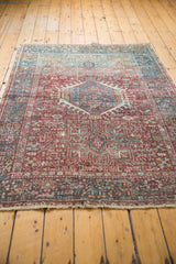 Vintage Karaja rug's distressed geometric border, brick red, teal blue patterns, and natural fringe.