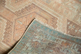Distressed Serab rug corner, showing even wear, hand-knotted foundation, and geometric patterns.