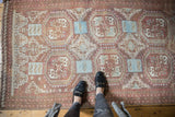 Faded cranberry and powder blue rams horn medallions on a distressed vintage Belouch rug.